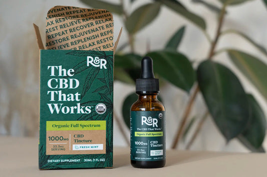 An R&R 1000mg organic full-spectrum tincture placed on a white floor