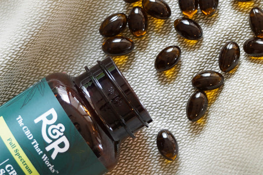 R&R CBD Softgels spilled onto a cream colored surface